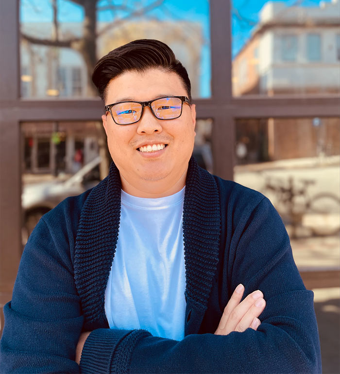 James Lee smiling downtown in front of building